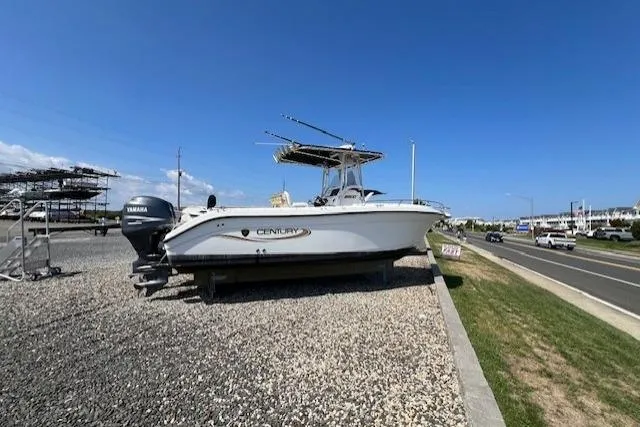 Slide: The Image of 2004 Century 2600 CC boat with Yamaha engine on gravel near a road. - 1