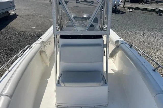 Slide: The Image of 2004 Century 2600 CC boat interior with seating and console, docked on gravel. - 12