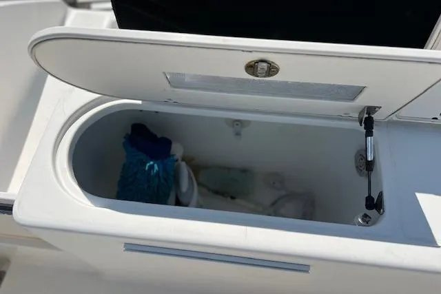 Slide: The Image of Open storage compartment on 2004 Century 2600 CC boat, containing cleaning supplies. - 16