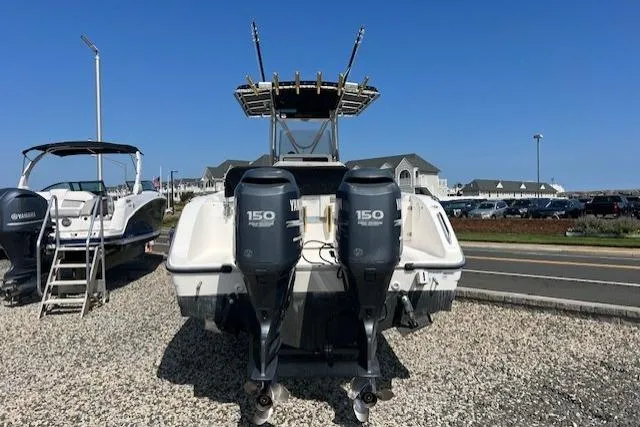 Slide: The Image of 2004 Century 2600 CC boat with dual Yamaha 150 engines, parked on gravel. - 4