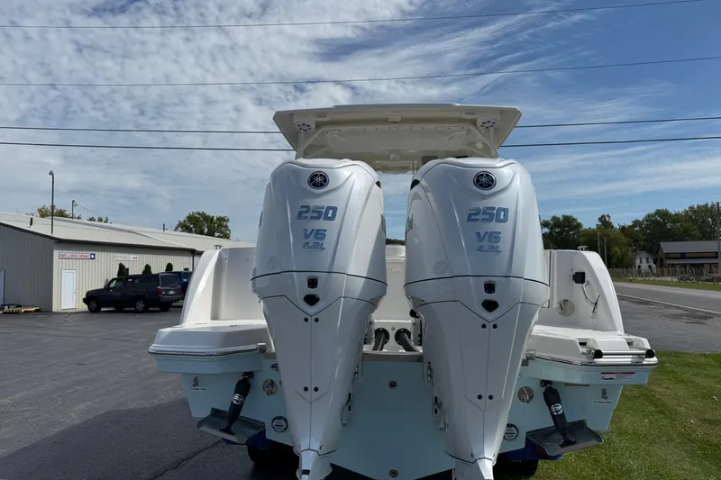 Slide: The Image of 2026 Sailfish 276 DC boat with dual 250 V6 outboard engines, parked outdoors. - 2