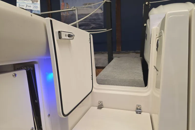 Slide: The Image of 2026 Sailfish 276 DC boat interior with open storage compartment and blue LED lighting. - 23