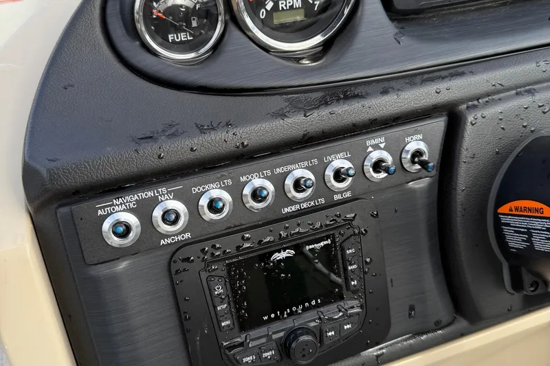 Slide: The Image of Control panel of 2025 Berkshire 22CL CTS boat with switches and gauges. - 14