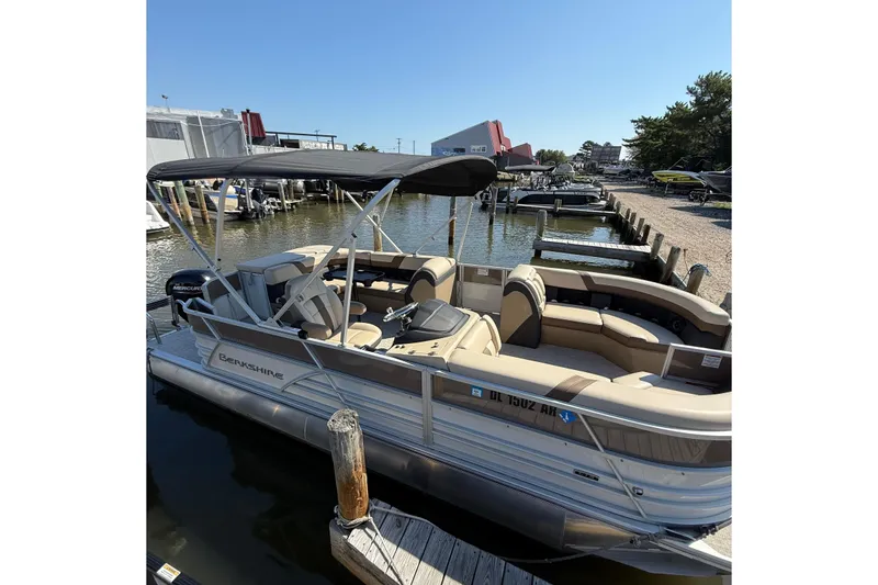 Slide: The Image of 2025 Berkshire 22CL CTS pontoon boat with cover, parked in a lot. - 2