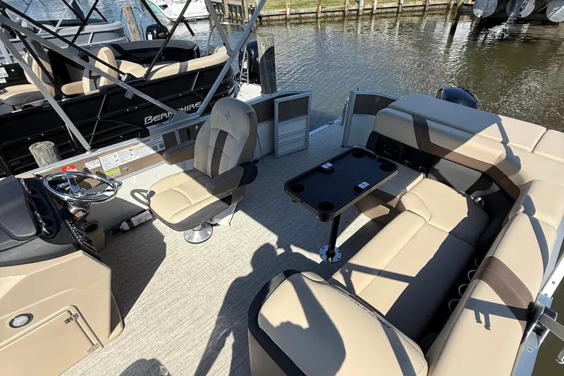 Slide: The Image of 2025 Berkshire 22CL CTS pontoon boat with Mercury engine, docked under cloudy sky. - 4