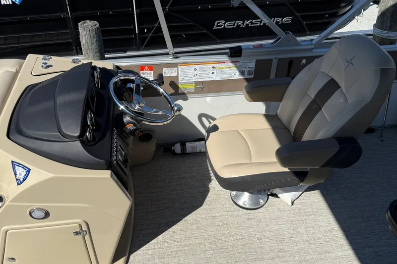 Slide: The Image of 2025 Berkshire 22CL CTS pontoon boat with Mercury engine, covered and parked outdoors. - 7
