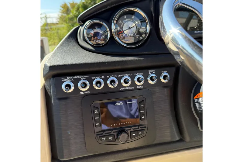 Slide: The Image of 2025 Berkshire 22CL CTS pontoon boat with canopy and outboard motor, parked outdoors. - 8