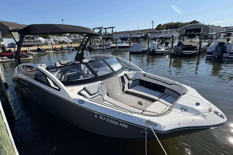 The Image of 2019 Yamaha 275 SE boat docked at marina, featuring sleek design and spacious seating. - 1