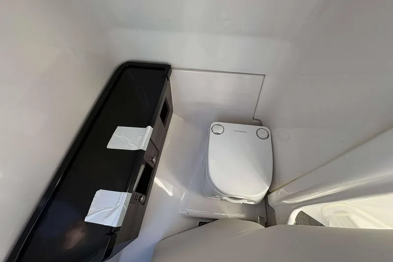 Slide: The Image of 2019 Yamaha 275 SE boat interior with compact marine toilet and storage area. - 12