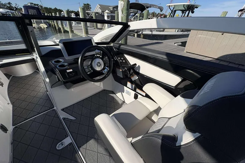 Slide: The Image of 2019 Yamaha 275 SE boat interior with steering wheel and dashboard, docked at marina. - 19