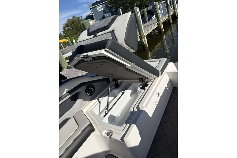 Slide: The Image of 2019 Yamaha 275 SE boat seat with open storage compartment, dockside view. - 24