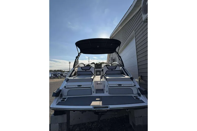 Slide: The Image of 2019 Yamaha 275 SE boat with sleek design, docked near a building under clear skies. - 25