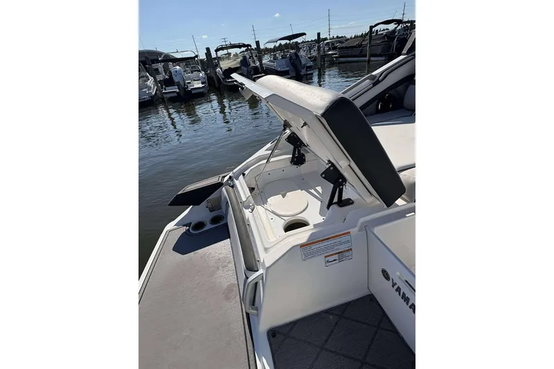 Slide: The Image of 2019 Yamaha 275 SE boat with open storage compartment at marina. - 7