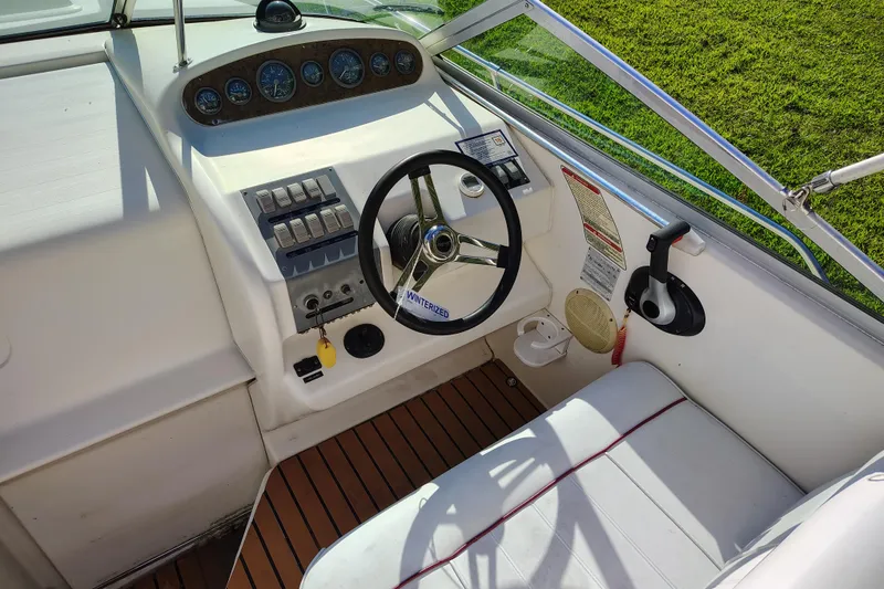 Slide: The Image of 1995 Sea Ray 250 Sundancer helm with steering wheel, gauges, and controls. - 15