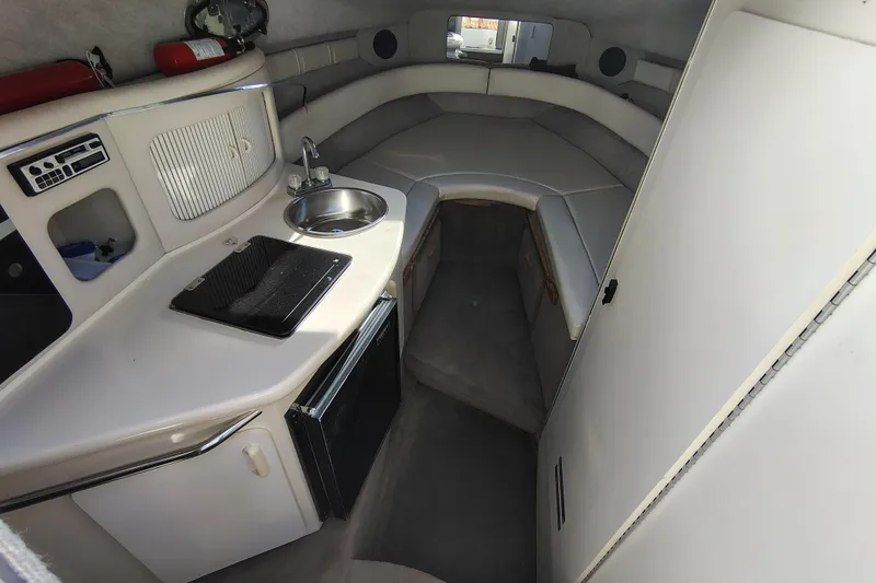 Slide: The Image of Interior of 1995 Sea Ray 250 Sundancer boat with kitchenette and seating area. - 17