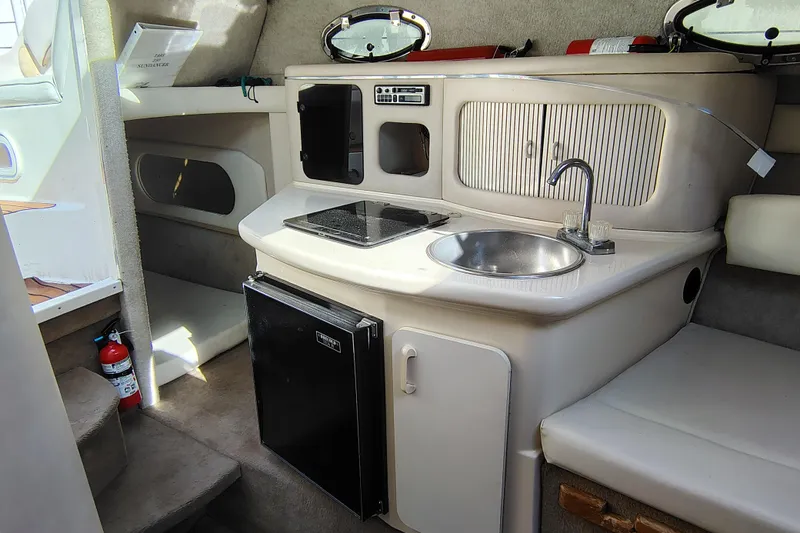 Slide: The Image of Interior of 1995 Sea Ray 250 Sundancer boat with kitchenette and sink. - 2
