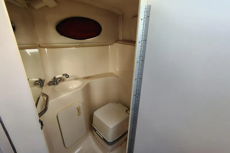 Slide: The Image of 1995 Sea Ray 250 Sundancer bathroom with sink, toilet, and mirror. - 22