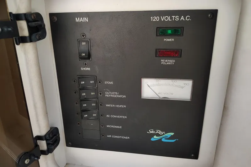 Slide: The Image of Electrical control panel on a 1995 Sea Ray 250 Sundancer boat, showing switches and voltage meter. - 25
