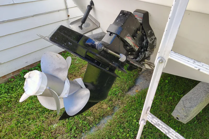 Slide: The Image of 1995 Sea Ray 250 Sundancer boat propeller and outdrive on grass. - 27