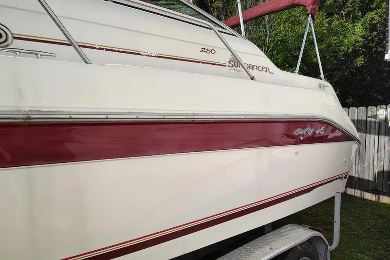 Slide: The Image of 1995 Sea Ray 250 Sundancer boat with red and white exterior on a trailer. - 9