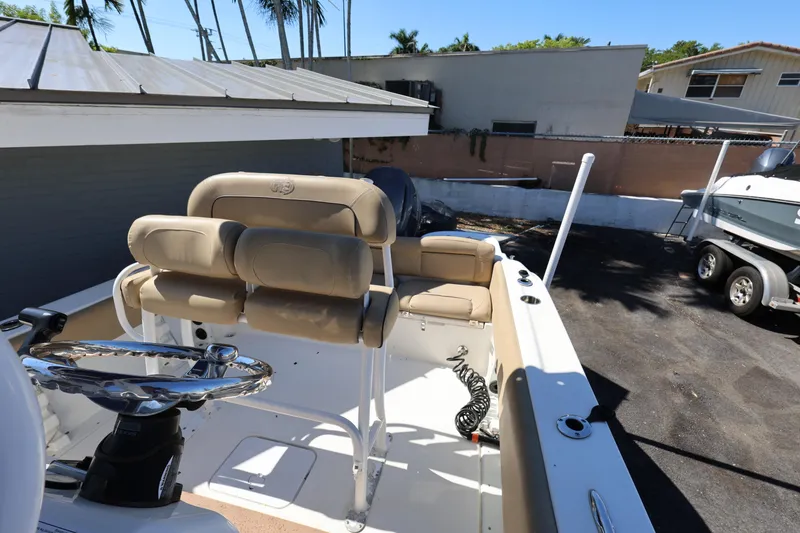 Slide: The Image of 2019 NauticStar 2302 Legacy boat interior with beige seating and steering wheel. - 13
