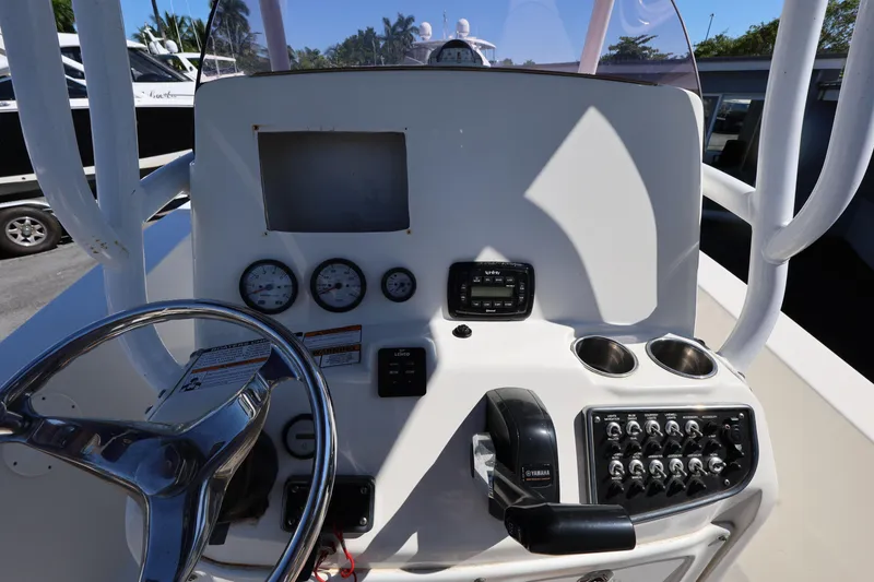 Slide: The Image of 2019 NauticStar 2302 Legacy boat dashboard with steering wheel and control panel. - 14