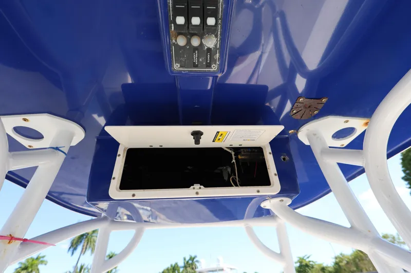 Slide: The Image of 2019 NauticStar 2302 Legacy boat console with open storage compartment and control panel. - 17