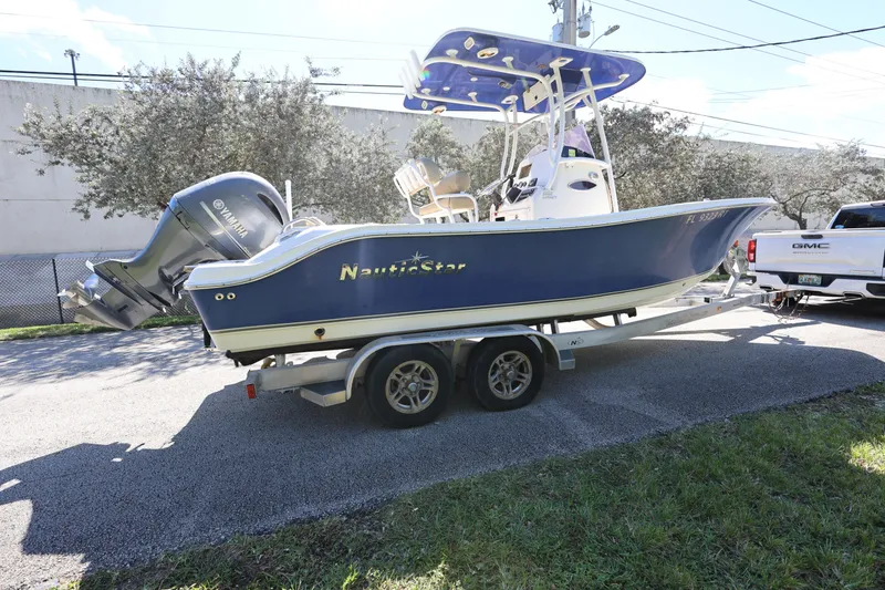 Slide: The Image of 2019 NauticStar 2302 Legacy boat on trailer, blue hull, Yamaha outboard engine. - 6