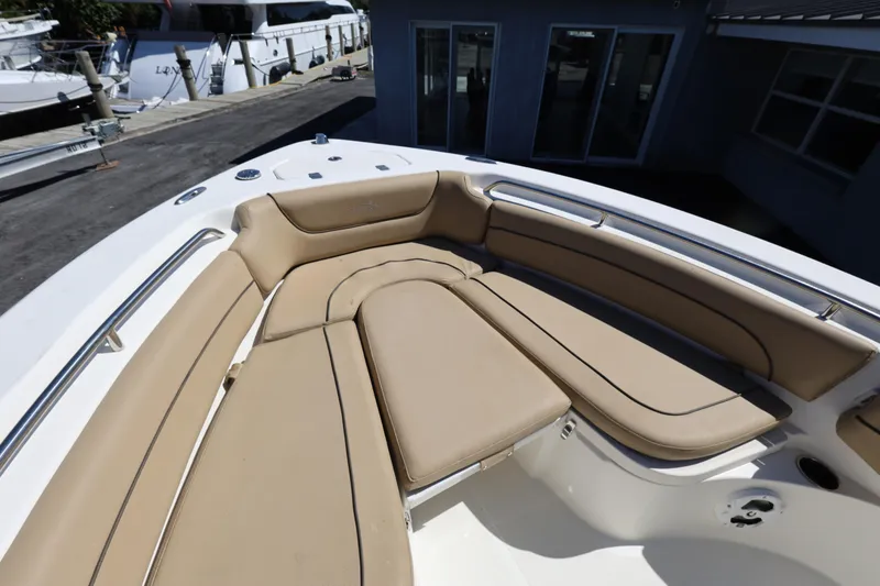 Slide: The Image of 2019 NauticStar 2302 Legacy boat with tan cushioned seating in the bow area. - 8