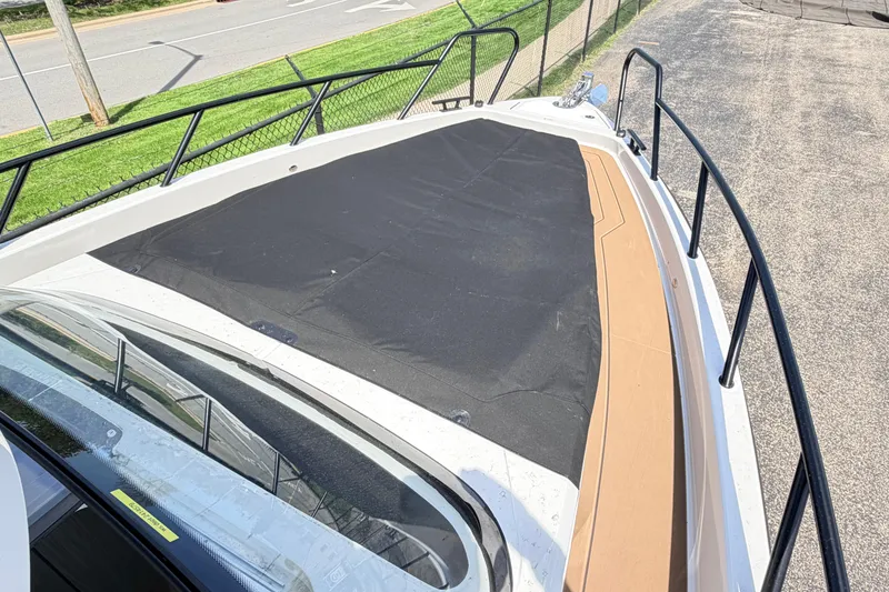 Slide: The Image of 2026 Navan S30 boat deck with black cover and railing, parked near a road. - 20