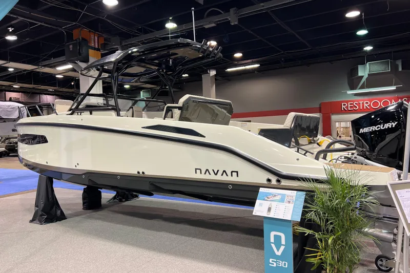 Slide: The Image of 2026 Navan S30 boat displayed indoors with Mercury engine, modern design. - 4