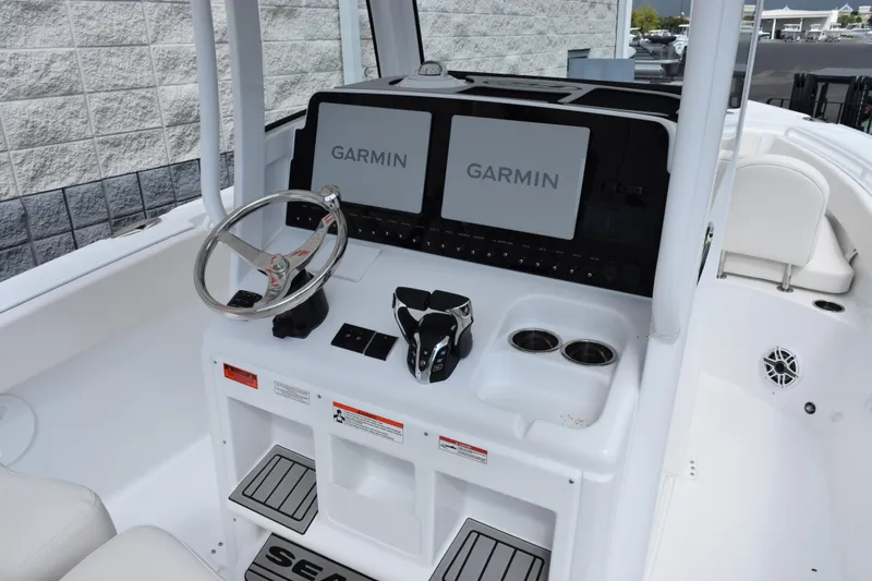 Slide: The Image of 2026 Sea Hunt Ultra 265 SE boat dashboard with Garmin navigation displays. - 8