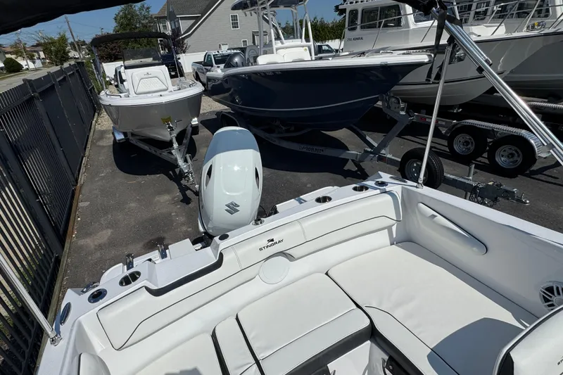 Slide: The Image of 2026 Stingray 172 SC boat with Suzuki outboard motor in a marina setting. - 4