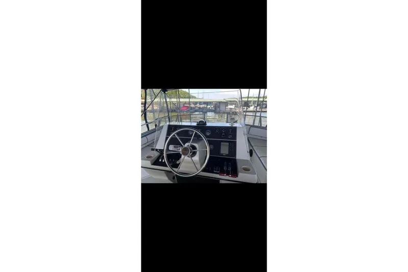 Slide: The Image of 1990 Carver 34 - 38 boat helm with steering wheel and control panel. - 14