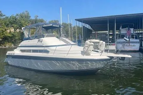 Slide: The Image of 1990 Carver 34 - 38 boat docked in a marina under clear blue skies. - 2