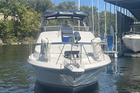 Slide: The Image of 1990 Carver 34-38 yacht docked on a sunny day, surrounded by trees and water. - 4