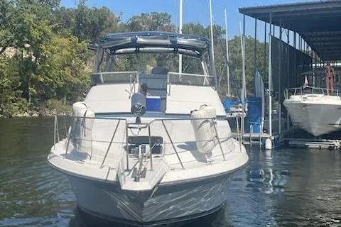 Slide: The Image of 1990 Carver 34 - 38 yacht docked in a marina, surrounded by trees and boats. - 5