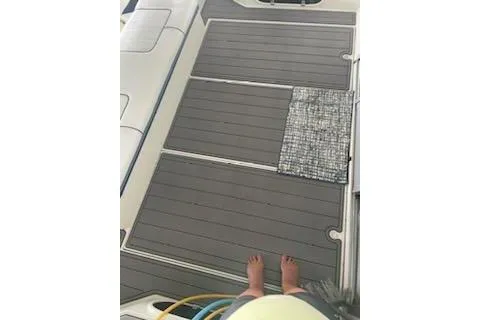 Slide: The Image of 1990 Carver 34-38 boat deck with gray flooring and a small mat. - 16