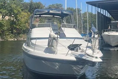 Slide: The Image of 1990 Carver 34-38 boat docked on a sunny day, surrounded by trees and water. - 3