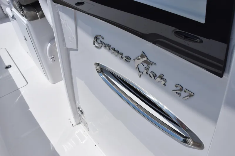 Slide: The Image of 2026 Sea Hunt Gamefish 27 Forward Seating boat detail, showcasing sleek design and logo. - 14