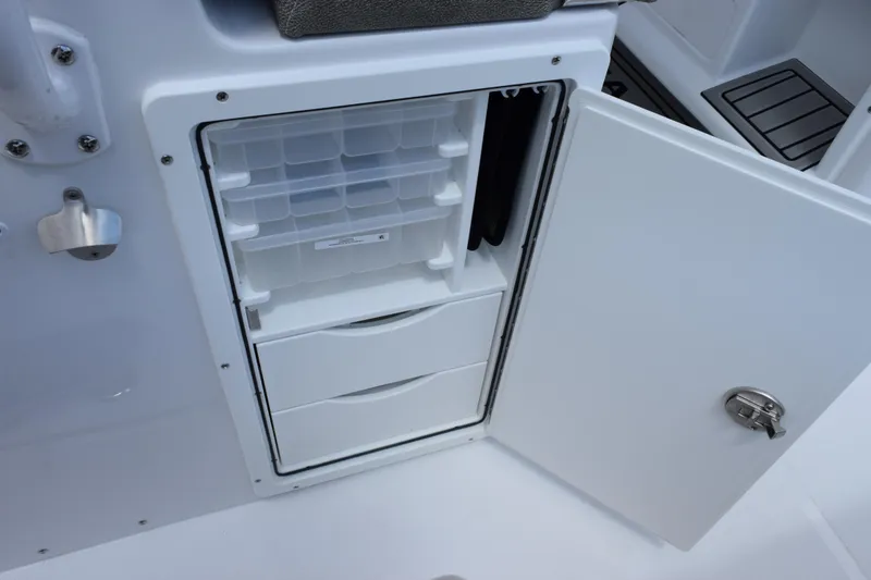 Slide: The Image of Open storage compartment on 2026 Sea Hunt Gamefish 27 boat, featuring organized drawers and shelves. - 24