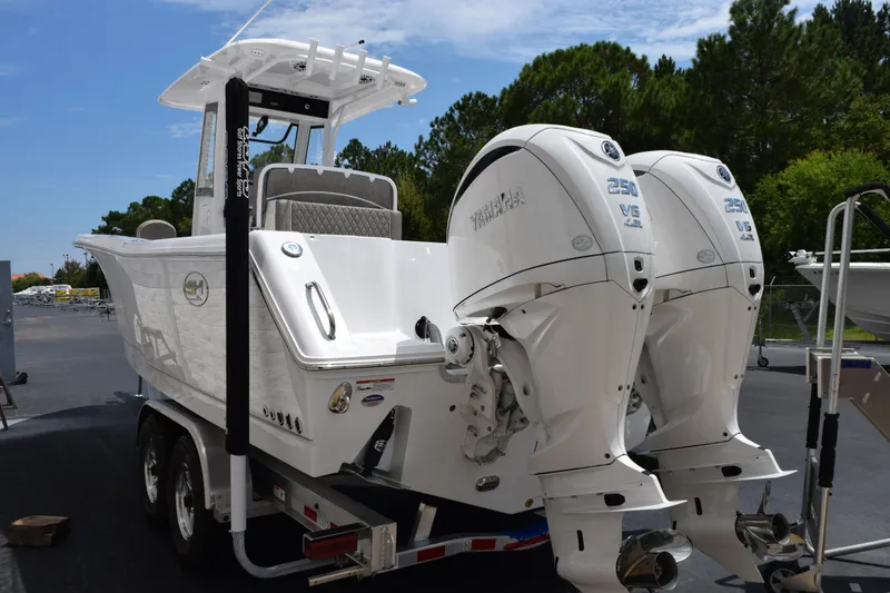 Slide: The Image of 2026 Sea Hunt Gamefish 27 boat with dual Yamaha 250 engines, parked outdoors. - 6