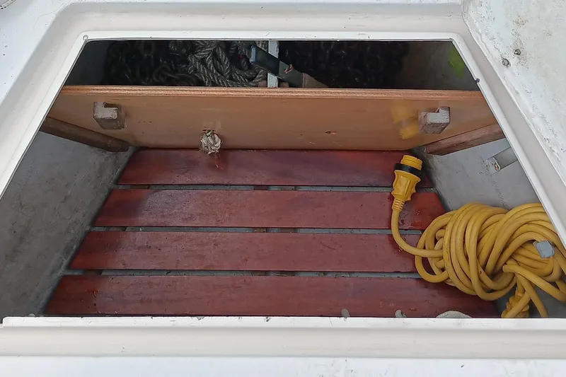 Slide: The Image of Open storage compartment on 1991 Gozzard 31 boat with coiled yellow cable. - 10