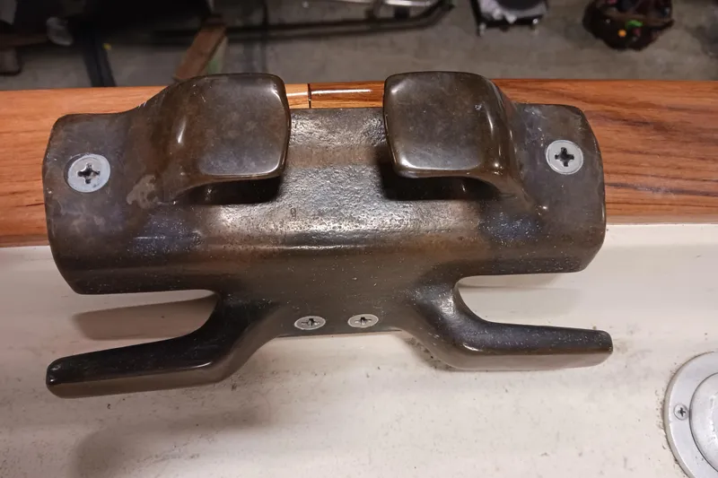 Slide: The Image of Bronze cleat on 1991 Gozzard 31 sailboat, mounted on wooden rail. - 13
