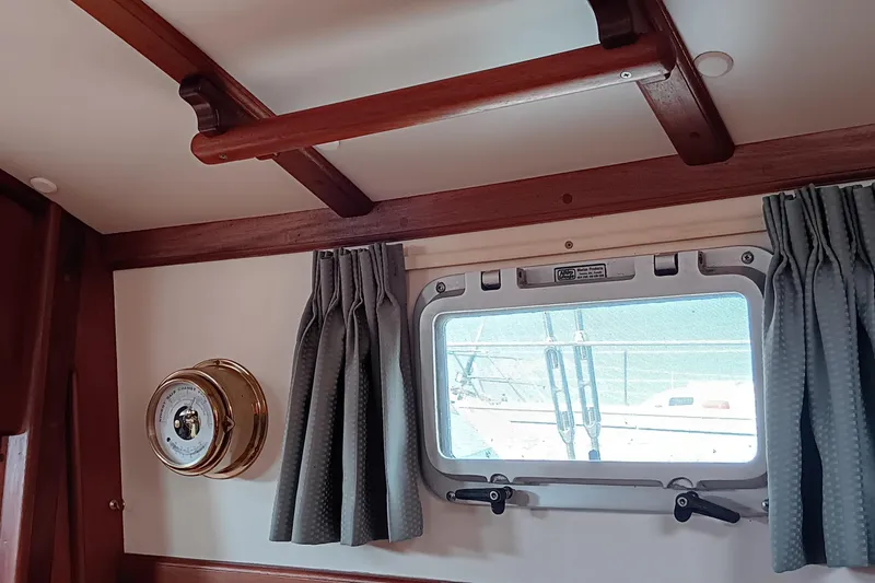 Slide: The Image of Interior of 1991 Gozzard 31 sailboat with porthole, curtains, and brass barometer. - 20