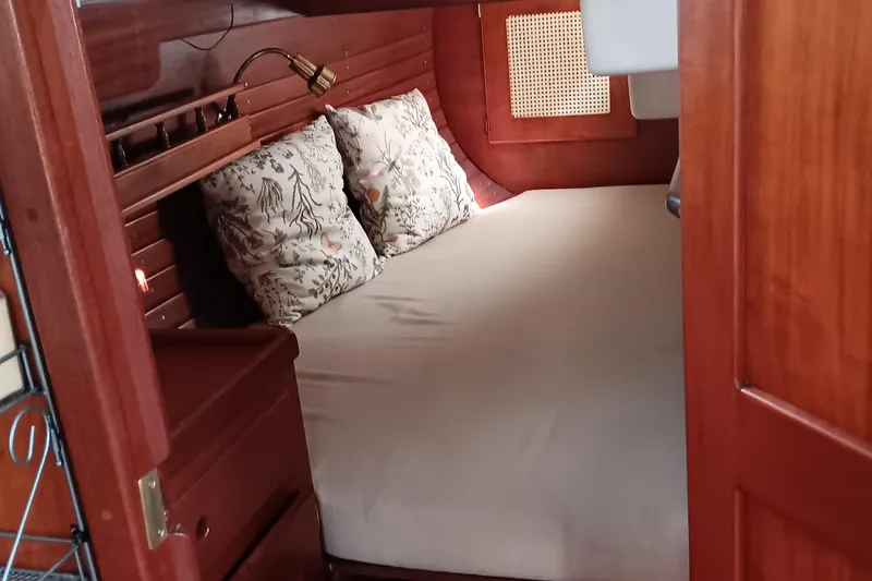 Slide: The Image of Cozy cabin interior of 1991 Gozzard 31 sailboat with wooden finish and floral pillows. - 22