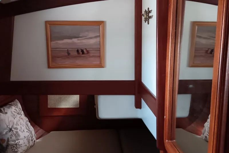 Slide: The Image of Cozy cabin interior of 1991 Gozzard 31 sailboat with framed artwork and wooden accents. - 23
