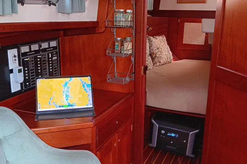 Slide: The Image of Cozy interior of a 1991 Gozzard 31 sailboat with navigation setup and comfortable sleeping area. - 24