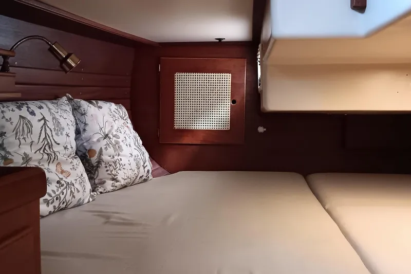 Slide: The Image of Cozy cabin interior of 1991 Gozzard 31 sailboat with floral pillows and wooden accents. - 25