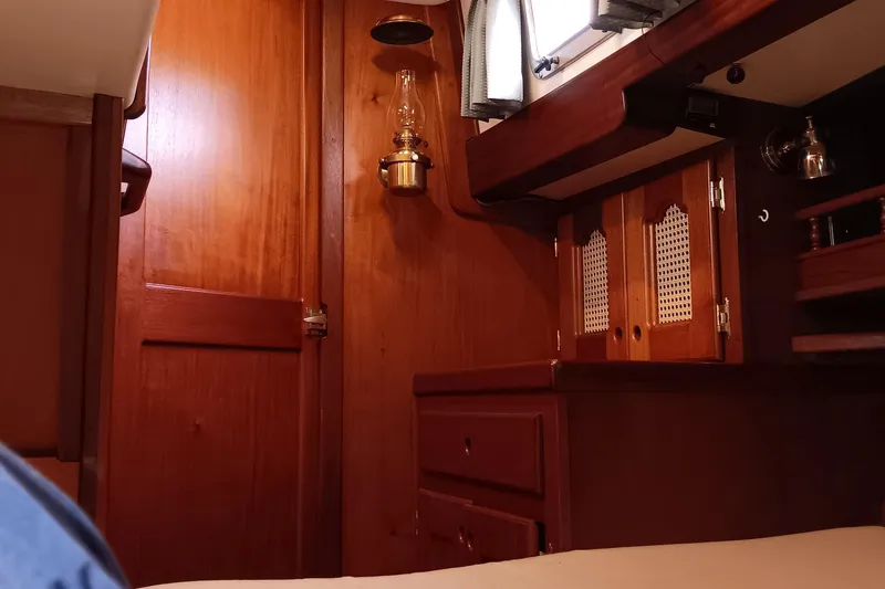 Slide: The Image of Cozy wooden interior of a 1991 Gozzard 31 sailboat cabin with vintage lamp. - 27